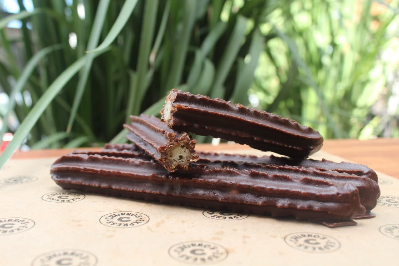 Churros bañados en chocolate y decorados con almendras